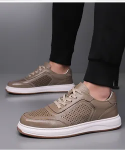 Detail van ademende kaki geperforeerde lederen sneakers voor heren gedragen aan echte voeten.