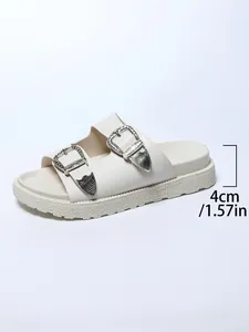 Détail montrant la plateforme de 4cm et les boucles argentées sur la sandale crème.