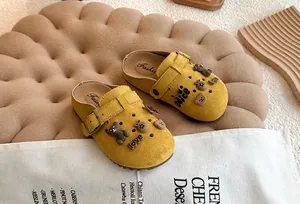 Gedetailleerd overzicht van gele ademende kinderklompen met schattige berenhangers