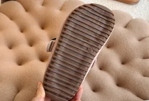 Gedetailleerd overzicht van de antislip bruine rubberen zool van een kinderclog