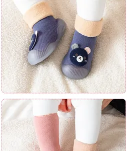 Vue détaillée de l'écusson ours et du col en peluche doux sur les chaussons pour bébé