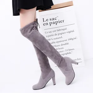 Detail of grey suede-like over-the-knee high heel boots with tie-back design.
