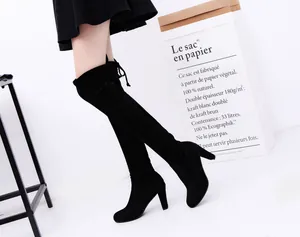 Side view showing the fit and texture of elegant black over-the-knee boots with high heels.