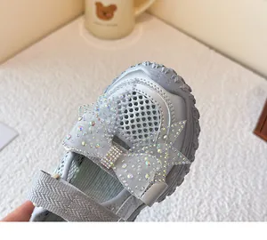 Detailansicht der silbernen Mädchen-Sandale mit funkelnder Strass-Schleife.