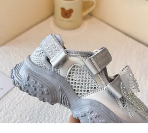 Nahaufnahme silberner, atmungsaktiver Mesh-Sandalen für Mädchen mit Strass-Schleife