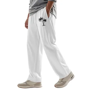 Close-up detail of men's breathable white linen wide-leg pants with black palm tree print