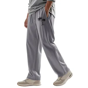 Detail of men's grey linen wide-leg pants featuring a black palm tree print design.