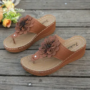 Detailed shot of brown women's platform wedge sandals featuring a large decorative flower