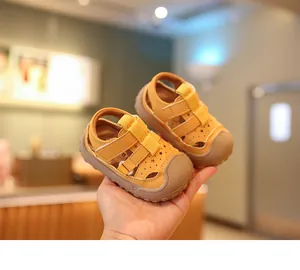 Detailansicht der gelben Babysandalen mit geschlossener Zehenkappe und Sternenmuster.