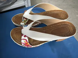 Detail view of floral embroidered chunky heel thong sandals for women's summer style.