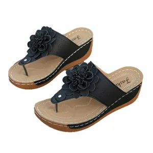 Elegant women's black wedge thong sandals with decorative flower and open toe design