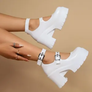 Dettaglio delle eleganti scarpe Mary Jane bianche con plateau e tacco alto spesso.