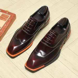 Macro view of burgundy leather Oxford shoes with distinctive orange accent soles
