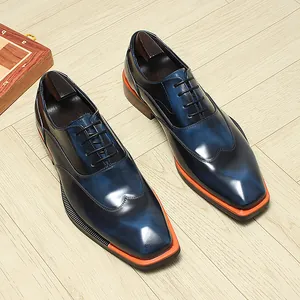 Detailed view of navy leather Oxford shoes featuring square toe and orange contrast sole