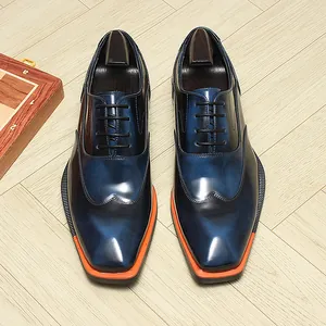 Detailed close-up of men's formal blue gradient Oxford shoes with unique orange sole detail