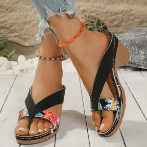 Detailed view of bohemian style floral flip-flop sandals with chunky heels for women