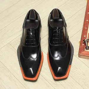 High-angle view of black glossy leather Oxford shoes featuring square toe and orange welt detail