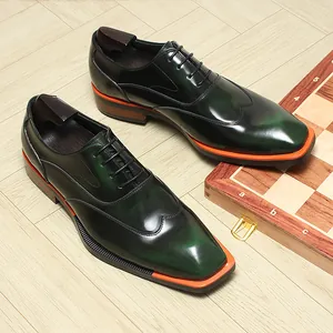 Close-up of green patina leather oxford shoes with stylish orange sole accents