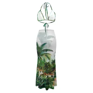 Tropical palm print three-piece bikini set with sheer mesh maxi beach skirt detail.