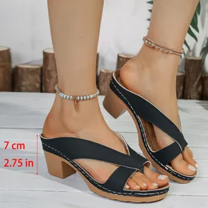 Elegant black chunky heel sandals with criss-cross straps and detailed 7cm heel height