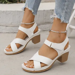 Vue détaillée de sandales blanches à plateforme avec talons épais et velcro.
