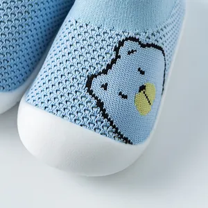 Gros plan de chaussures de marche pour bébé en maille bleue avec broderie animale