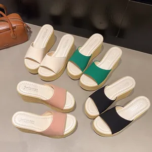Diverse paia di sandali con zeppa e plateau nei colori verde rosa nero e crema chiaro