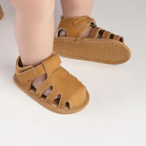 Primo piano di sandali marroni per primi passi da neonato con suola antiscivolo a puntini