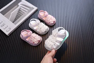 Detailansicht von Kleinkindersandalen mit LED-Licht, Blumenverzierung und weicher Sohle.
