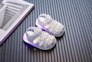 Detailansicht stilvoller weißer Babysandalen für Mädchen mit LED-Lichtsohlen und Blumen