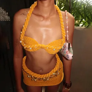 Dettaglio completo top a fascia e minigonna in maglia gialla con perle e farfalla