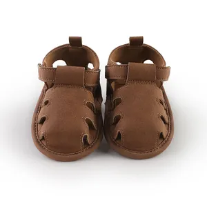 Vista frontale di sandali da passeggio per bambini marroni con design traforato.
