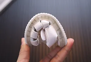 Detailaufnahme der flexiblen weichen Sohle von weißen LED-Leuchtsandalen für Mädchen.