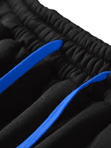 Macro detail of the elastic waistband with a bright blue drawstring on black fleece joggers.