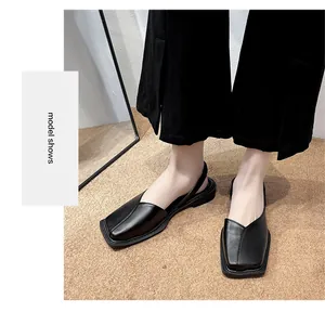 Detailed close-up view of elegant black square-toe slingback flat shoes worn by a model