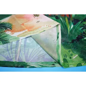 Close-up of mesh beach skirt showing green tropical leaf print and stitching quality