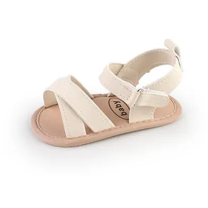 Close-up of cream baby summer sandals with criss-cross straps and velcro closure