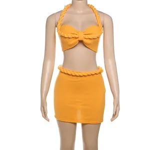 Completo sexy in maglia gialla con top allacciato al collo e minigonna con perline
