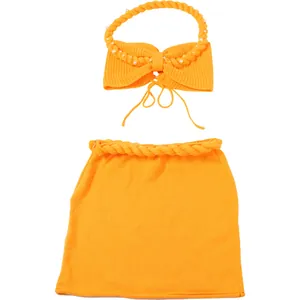 Completo due pezzi in maglia arancione vivace con top all'americana e gonna con perle