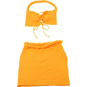 Vista dettagliata del set in maglia arancione con top all'americana e minigonna