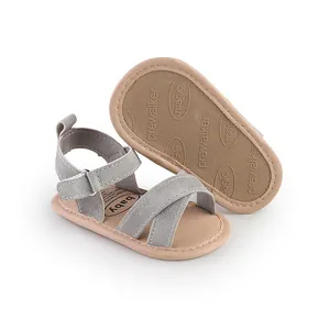 Close-up of grey suede infant walker sandals with textured non-slip rubber soles.