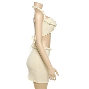 Dettaglio laterale di un set coordinato top halter e minigonna in maglia con perle.