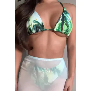 Model wearing tropical palm print bikini set with white sheer mesh cover-up skirt