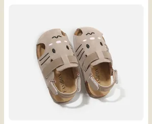 Top view of children's suede sandals featuring cute cat face embroidery and closed-toe