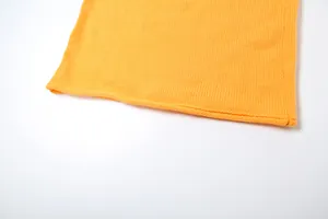Primo piano della fine trama in maglia gialla e dell'orlo di un completo estivo da donna.