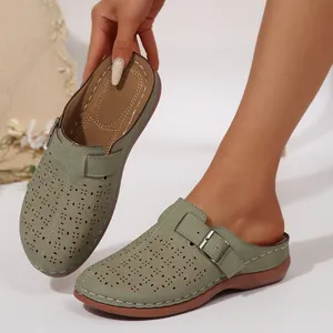 Gros plan détaillé des mules compensées pour femmes en vert sauge ajouré au laser