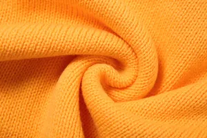 Vista macro della trama del tessuto a maglia arancione vivace per un completo estivo a due pezzi