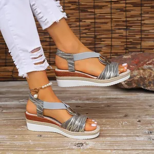 Detailed view of women's grey wedge sandals with metallic patterns and ring buckle