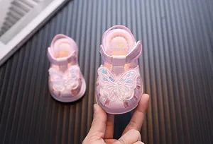 Close-up of pink baby girl sandals with decorative butterfly and light-up sole