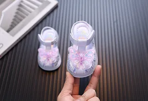 Detailed view of baby girl sandals featuring a sparkling sequined butterfly applique
